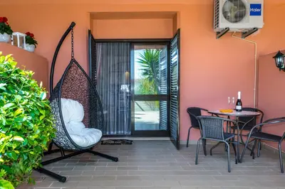 a patio with a swing and a table and chairs at Clementina Apartment in Albufeira