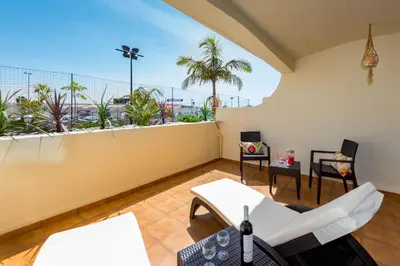 a balcony with white furniture and a view of the city at Clementina Apartment in Albufeira