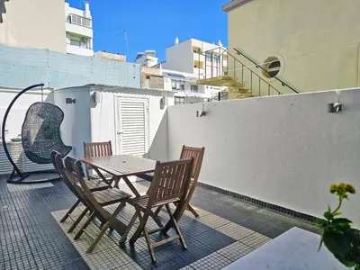 a patio with a table and chairs on a balcony at Blife Luya private rooms in Faro