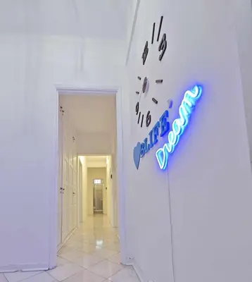 a neon sign on a wall in a hallway at Blife Luya private rooms in Faro