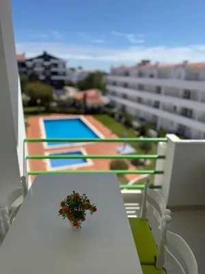 a table with a flower arrangement on it on a balcony at Jardim Santa Eulália By Albufeira Rental in Albufeira