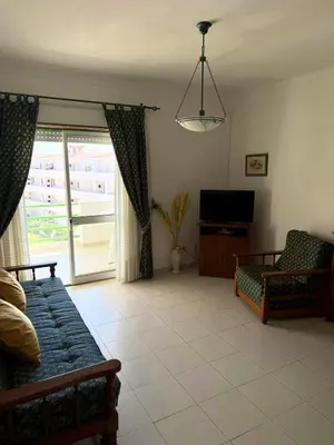 a living room with a couch and a tv at Jardim Santa Eulália By Albufeira Rental in Albufeira