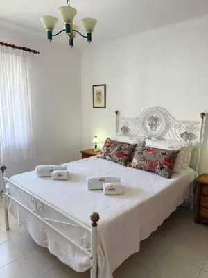 a bedroom with a white bed with towels on it at Jardim Santa Eulália By Albufeira Rental in Albufeira