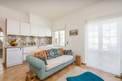a living room with a blue couch in a kitchen at Sunny Flat w/ Balcony near the Sea by HostWise in Albufeira