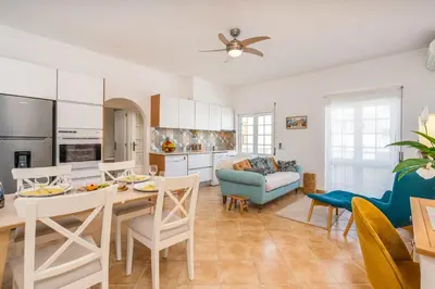 a kitchen and living room with a table and chairs at Sunny Flat w/ Balcony near the Sea by HostWise in Albufeira