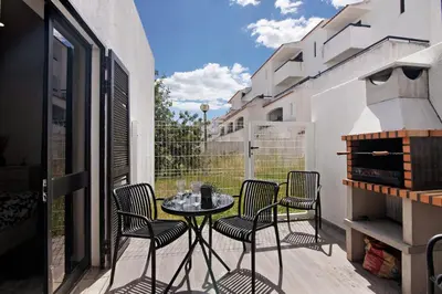 a patio with a table and chairs on a balcony at Amazing Oura Beach Apartment in Albufeira
