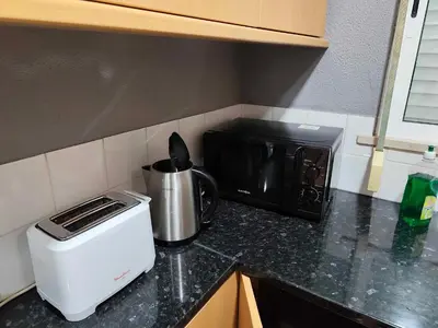a kitchen counter with a toaster and a black microwave at Albufeira INN - Vale Navio T2 in Albufeira