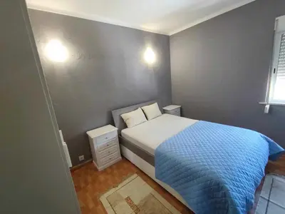 a small bedroom with a bed with a blue blanket at Albufeira INN - Vale Navio T2 in Albufeira