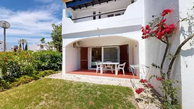 a white house with a table in the yard at Apartamento Studio Sao Rafael, 450m Praia in Albufeira