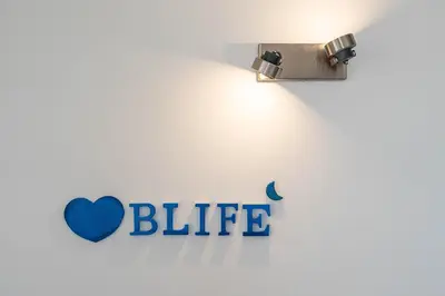 a blue heart sign on a wall with a light at Blife Riamya private rooms in Faro
