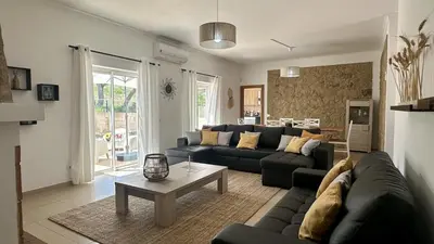 a living room with two black couches and a table at Casa do Campo by Check-in Portugal in Tunes