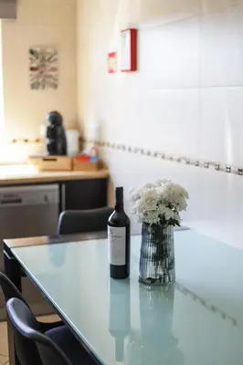 a bottle of wine sitting on a table with a vase of flowers at Silver Globe in Albufeira