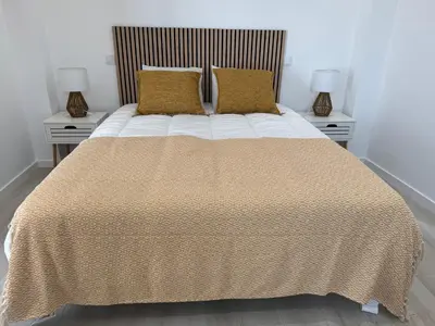 a bed with blue pillows and a blue wreath on the wall at Quinta da Pi Silveira in Loulé