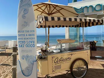 a food cart on the beach next to a surfboard at Serenity-First villa in Albufeira