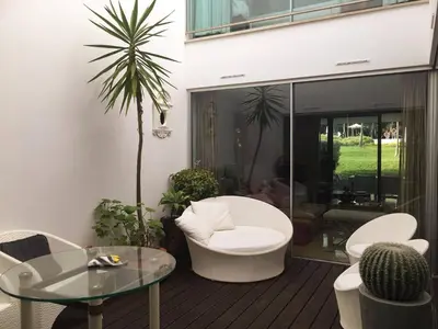 a patio with a table and chairs and a palm tree at Serenity-First villa in Albufeira
