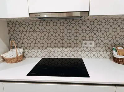 a kitchen with a stove top oven in a kitchen at Grey and Green, modern 2-bedroom apartment, AC, top location at faro's historic centre in Faro
