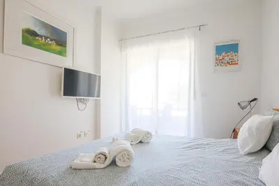 a bed with a black and white comforter on it at Apart Salgados Village - Near to the Beach - BY BEDZY in Guia