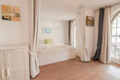 a white bedroom with a bed and a window at Old Village - Vilamoura T0 com pátio in Bicas