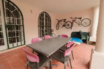 a table and chairs in a room with bikes on the wall at Old Village - Vilamoura T0 com pátio in Bicas