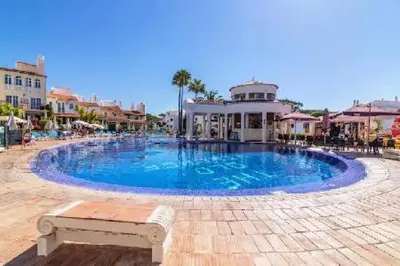 a large blue swimming pool in a resort at Old Village - Vilamoura T0 com pátio in Bicas