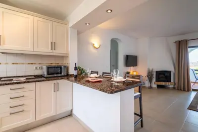 a kitchen with white cabinets and a counter top at Apartamento Sol & Mar by Portucasa in Albufeira