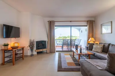 a living room with a couch and a fireplace at Apartamento Sol & Mar by Portucasa in Albufeira