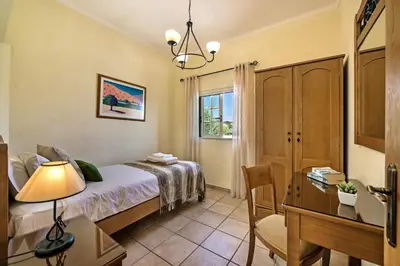 a bedroom with a bed and a desk and a chair at Rebela 1st Algarve Villa Holidays in Albufeira