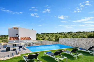 a villa with a swimming pool and lounge chairs at Cruzeiro by Check-in Portugal in Quarteira