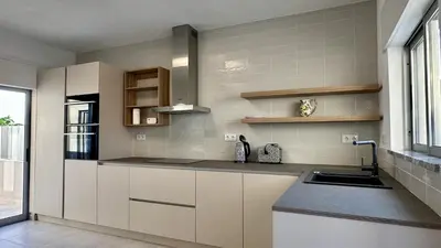a kitchen with white cabinets and a sink at Cruzeiro by Check-in Portugal in Quarteira