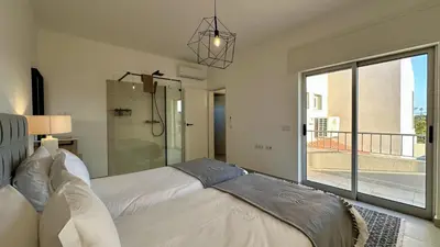 a bedroom with a large white bed and a balcony at Cruzeiro by Check-in Portugal in Quarteira