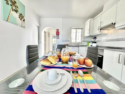 a kitchen with a table with plates and glasses of orange juice at Albufeira Tropical View 2 by Homing in Sesmarias