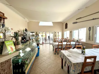 a restaurant with tables and chairs and a counter at Albufeira Tropical View 2 by Homing in Sesmarias