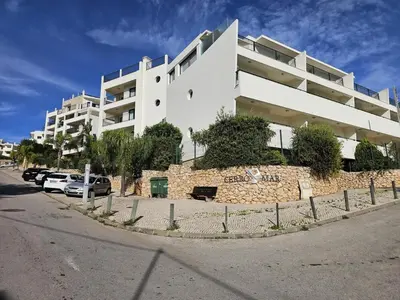 a large white building with cars parked in front of it at Brisa do Atlântico 201 in Albufeira