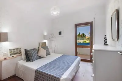 a bedroom with a bed and a view of the ocean at Santiago’s Oura House in Albufeira