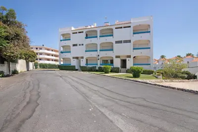 an empty street in front of a white building at Santiago’s Oura House in Albufeira