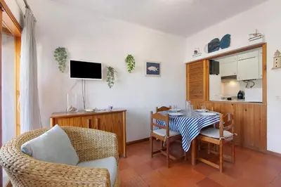 a kitchen and dining room with a table and chairs at Santiago’s Oura House in Albufeira
