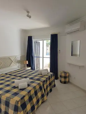 a bedroom with a blue and yellow checkered bed at Balaia Golf Village 122 in Albufeira