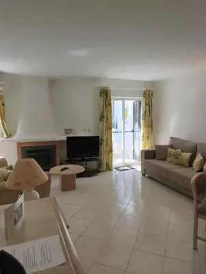 a living room with a couch and a tv at Balaia Golf Village 122 in Albufeira