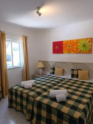 a bedroom with a bed with a checkered blanket at Balaia Golf Village 122 in Albufeira