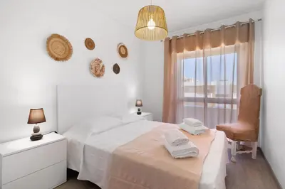 a white room with a chair and a door at Justo's House in Faro