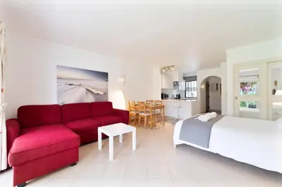 a living room with a red couch and a tv at Apt 77 - São Rafael by HelloVacations in Albufeira