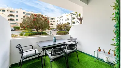 a table and chairs on a balcony with grass at Modern Studio with Balcony in Salgados by Lovelystay in Guia