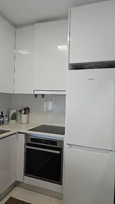 a kitchen with white cabinets and a black oven at Casa dos Sinos Beach Apartment 1 with Roof Terrace in Albufeira