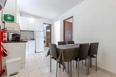 a dining room table with chairs and a kitchen at Maison A Quinta V2A 5 Personnes in Ferreiras
