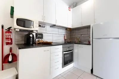 a kitchen with white cabinets and a white refrigerator at Maison A Quinta V2A 5 Personnes in Ferreiras