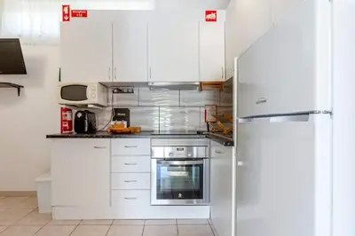a kitchen with white cabinets and a refrigerator at Maison A Quinta V2A 5 Personnes in Ferreiras