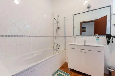 a bathroom with a tub and a sink and a mirror at Maison A Quinta V2B 7 Personnes in Ferreiras
