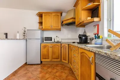 a kitchen with wooden cabinets and a white refrigerator at Maison A Quinta V2B 7 Personnes in Ferreiras