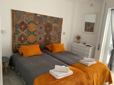 a bedroom with a large bed with orange pillows at Açoteias Falésia Studio Apartment in Olhos de Água