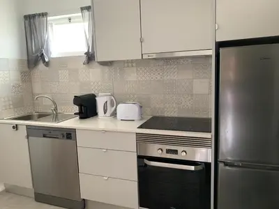a kitchen with a stainless steel refrigerator and a sink at Açoteias Falésia Studio Apartment in Olhos de Água